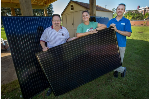 three people with solar panel 