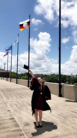 woman wearing graduation gown outside of Tucker Civic Center